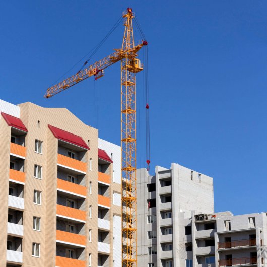 Industrial landscape, building crane against the blue sky.